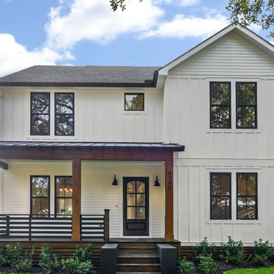 Large country white two-story mixed siding exterior home photo in New Orleans with a mixed material roof