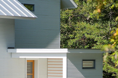 Modelo de fachada blanca de estilo de casa de campo de dos plantas con revestimiento de madera y tejado a dos aguas