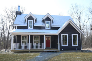 Example of a mid-sized country blue two-story wood exterior home design in New York with a shingle roof