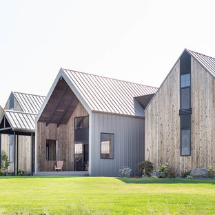 Diseño de fachada de casa marrón, actual, grande, de tres plantas, con revestimiento de madera, tejado a dos aguas y tejado de metal