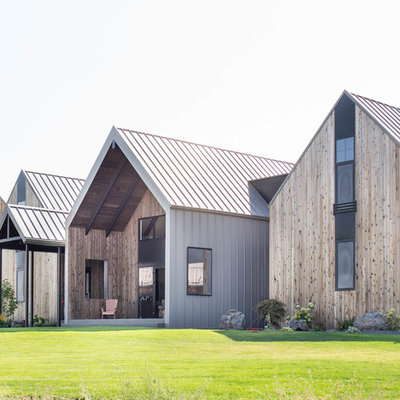 Example of a large trendy brown three-story wood exterior home design in Other with a metal roof