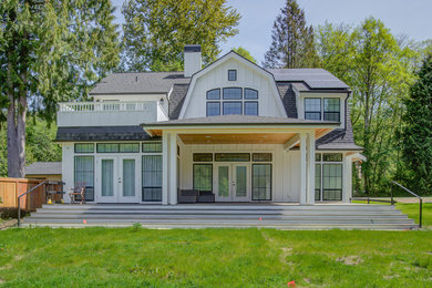 Ejemplo de fachada de casa blanca de estilo de casa de campo grande de dos plantas con revestimiento de madera, tejado a doble faldón y tejado de teja de madera