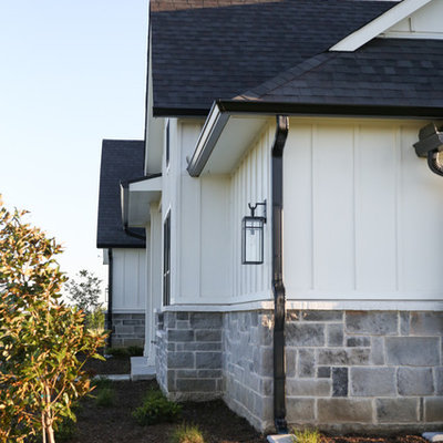 Large cottage white two-story mixed siding exterior home idea in Other with a shingle roof