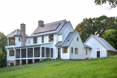Diseño de fachada de casa blanca de estilo de casa de campo de tamaño medio de tres plantas con revestimiento de aglomerado de cemento, tejado a dos aguas y tejado de metal