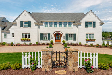 Inspiration for a farmhouse white two-story brick exterior home remodel in Charlotte