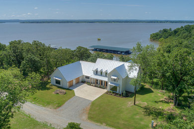 Diseño de fachada de casa blanca de estilo de casa de campo grande de dos plantas con revestimiento de aglomerado de cemento y tejado de metal