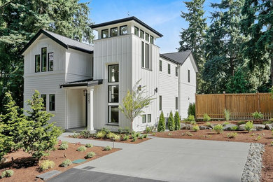 Farmhouse white three-story concrete fiberboard house exterior idea in Seattle with a metal roof