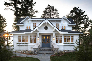 Ejemplo de fachada de casa blanca campestre de dos plantas con tejado a dos aguas y tejado de metal