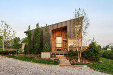 Imagen de fachada de casa marrón campestre de dos plantas con revestimiento de madera y tejado de un solo tendido