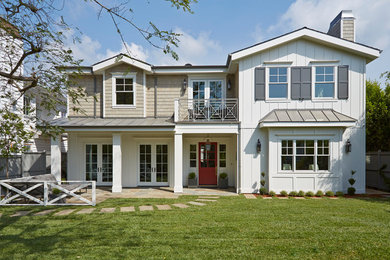 Inspiration for a large country white two-story mixed siding exterior home remodel in Los Angeles with a shingle roof