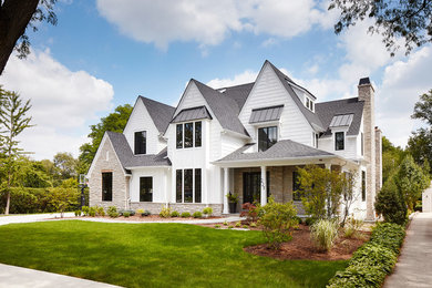 Foto de fachada de casa blanca de estilo de casa de campo grande de dos plantas con revestimientos combinados, tejado a dos aguas y tejado de teja de madera