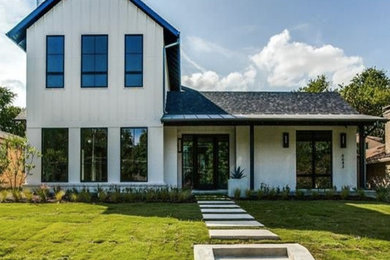 Imagen de fachada de casa blanca campestre de dos plantas con revestimientos combinados y tejado de teja de madera