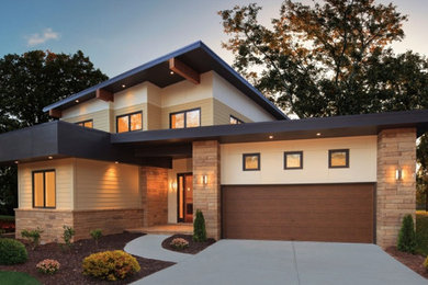 Imagen de fachada de casa beige actual grande de dos plantas con revestimientos combinados, tejado plano y techo verde