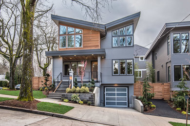 Example of a large minimalist gray three-story concrete fiberboard exterior home design in Portland with a mixed material roof
