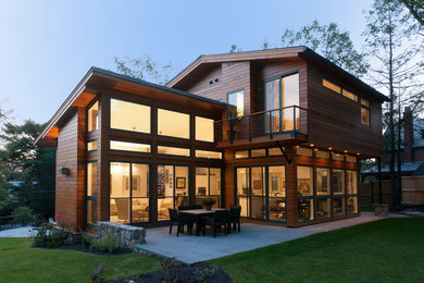 Exemple d'une façade de maison marron tendance en bois avec un toit plat.