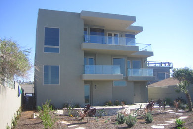 Imagen de fachada gris minimalista extra grande de tres plantas con revestimiento de estuco y tejado plano
