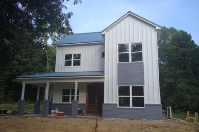 Kleines, Zweistöckiges Landhaus Einfamilienhaus mit Faserzement-Fassade, weißer Fassadenfarbe, Satteldach und Blechdach in Sonstige