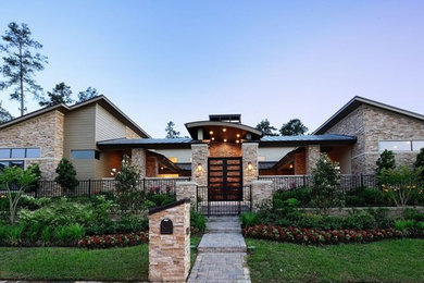 Photo of a large and beige modern bungalow house exterior in Houston with stone cladding.