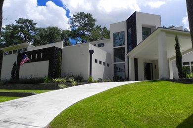 Inspiration for a large modern white two-story stucco flat roof remodel in Houston
