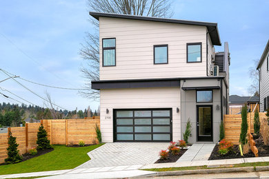 Example of a trendy white two-story house exterior design in Seattle with a shed roof