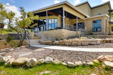Inspiration for a large contemporary yellow two-story exterior home remodel in Austin