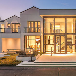 Example of a huge minimalist white two-story stucco exterior home design in Houston