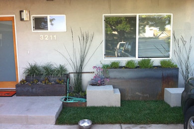 This is an example of a medium sized and beige modern bungalow render house exterior in Los Angeles.