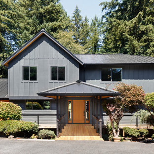 Large cottage black two-story vinyl exterior home idea in Portland with a metal roof
