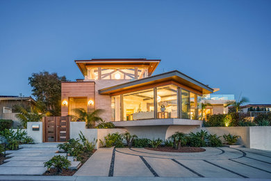 Diseño de fachada de casa beige costera extra grande de tres plantas con revestimientos combinados