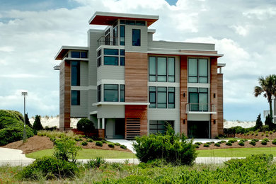 Foto de fachada de casa gris actual grande de tres plantas con revestimientos combinados y tejado plano