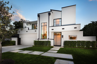 This is an example of a large and white traditional two floor render house exterior in Houston with a flat roof.