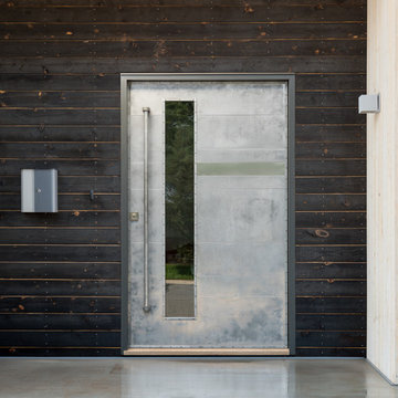 Modern pivot door wrapped in polished aluminum