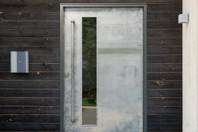 Modern pivot door wrapped in polished aluminum