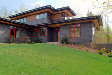 Modelo de fachada de casa multicolor de estilo americano grande de dos plantas con revestimiento de madera, tejado a cuatro aguas y tejado de teja de madera