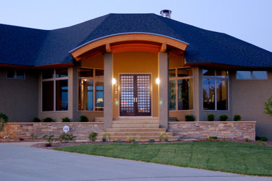 Ejemplo de fachada de casa beige clásica con revestimiento de estuco, tejado a cuatro aguas y tejado de teja de madera