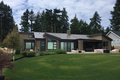 Exemple d'une grande façade de maison marron moderne en panneau de béton fibré de plain-pied avec un toit en appentis et un toit en métal.