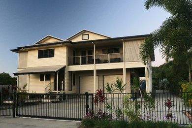 Photo of a large and beige world-inspired two floor house exterior in Brisbane with mixed cladding and a half-hip roof.