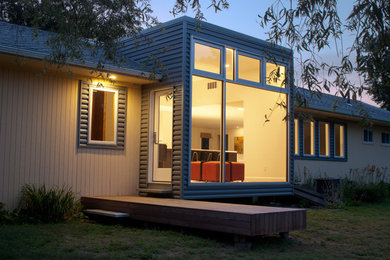 Idée de décoration pour une façade de maison métallique et beige design de plain-pied avec un toit à deux pans.