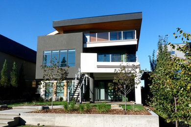 Photo of a large and white modern render house exterior in Edmonton with three floors and a flat roof.