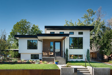 Diseño de fachada de casa blanca minimalista con revestimiento de estuco y tejado plano