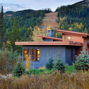 Example of a huge mountain style gray two-story stucco exterior home design in Other