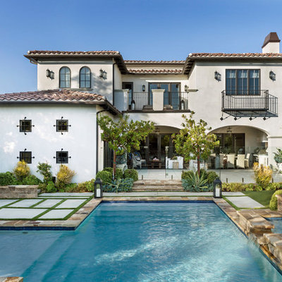 Mediterranean white two-story stucco house exterior idea in Other with a hip roof and a tile roof