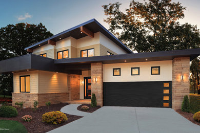 Ejemplo de fachada de casa beige actual de tamaño medio de dos plantas con revestimientos combinados y tejado plano