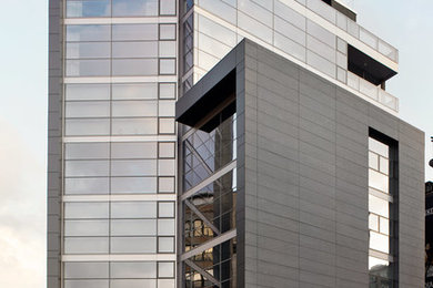 Imagen de fachada minimalista de tres plantas con revestimientos combinados