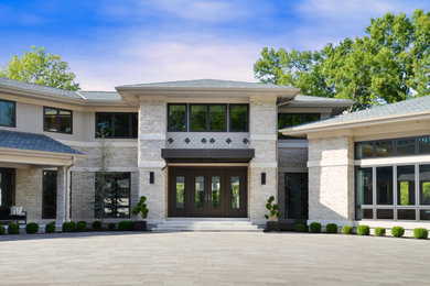 Huge trendy beige two-story stone exterior home photo with a shingle roof