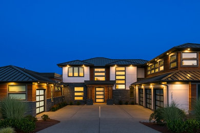 Example of a large trendy gray two-story mixed siding house exterior design in Seattle with a hip roof and a metal roof