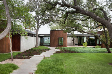 Inspiration for a large and brown contemporary bungalow house exterior in Austin with a flat roof.