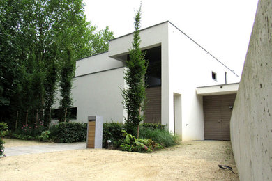 Foto de fachada blanca moderna con revestimiento de estuco y tejado plano