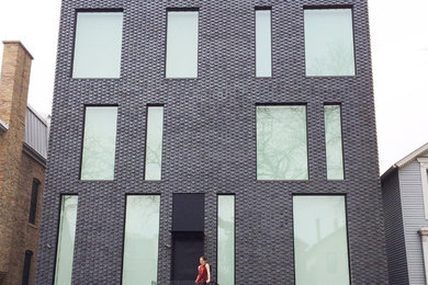 Foto de fachada negra moderna grande de tres plantas con revestimiento de ladrillo