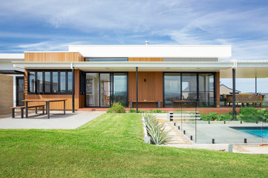 Diseño de fachada de casa multicolor contemporánea de tamaño medio de una planta con revestimiento de madera, tejado plano y tejado de metal
